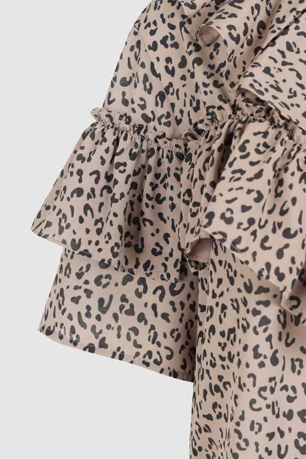 **Ruffle Point Leopard 블라우스 (브라운)**

페미닌하고 클래식한 무드를 연출하는 Ruffle Point Leopard 블라우스입니다. 브라운 컬러의 레오파드(호피) 패턴이 특징이며, 봄, 여름, 가을 계절에 활용하기 좋습니다. 루즈핏으로 편안하게 착용 가능하며, 비대칭 네크라인과 긴소매, 소매 셔링, 볼륨감있는 디자인이 돋보입니다. 뒷넥 단추 여밈으로 간편하게 탈착용할 수 있으며, 데이트룩, 카페룩, 모임룩 등 다양한 TPO에 맞춰 클래식, 로맨틱, 미니멀 스타일을 연출해보세요.
