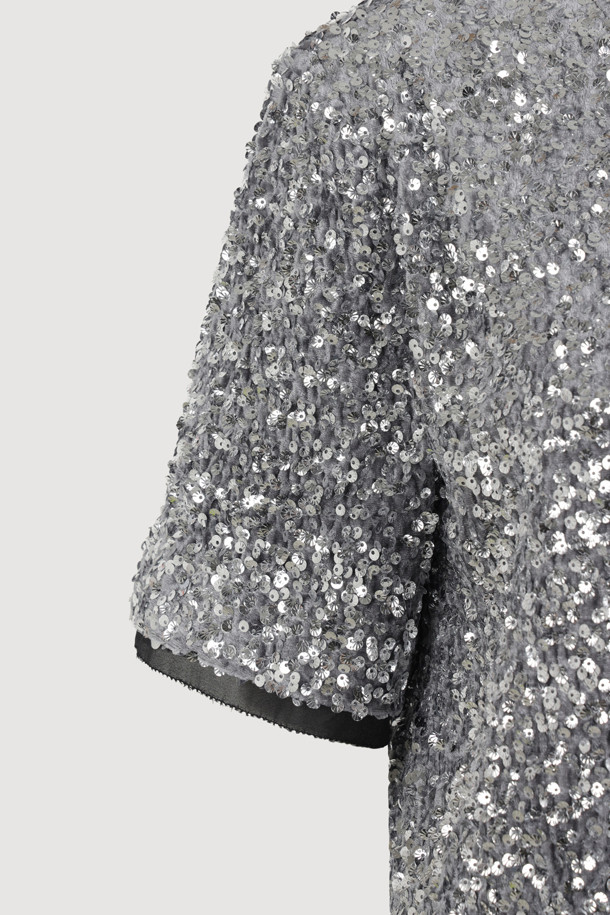 [Atelier] 스팽글 하프 슬리브 블라우스 (실버)는 여성 고객을 위한 블라우스입니다. 벨벳 소재에 실버 컬러의 스팽글 장식이 더해져 화려하면서도 유니크한 스타일을 연출합니다. 반소매 기장의 일자핏 블라우스로, 뒤 단추 여밈과 네크라인, 소매단, 밑단의 시어 배색이 특징입니다. 가슴 부분의 니트 장식이 포인트로, 파티룩, 연말 모임룩, 모임룩 등 TPO에 활용 가능하며, 클래식, 시크, 미니멀 스타일을 선호하는 고객에게 추천합니다.
