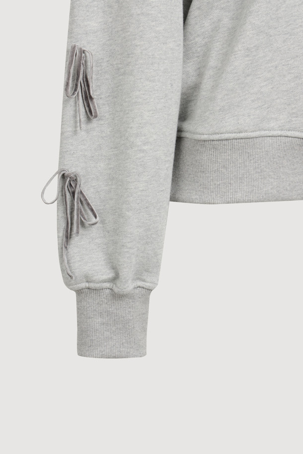 멜란지 그레이 컬러의 리본 포인트 맨투맨 티셔츠입니다. 캐주얼하고 미니멀한 스타일로, 봄, 가을에 어울리는 크롭 기장의 긴소매 디자인입니다. 오른쪽 소매에는 벨벳 리본 장식이, 가슴에는 슈에뜨 자수가 포인트로 자리 잡고 있습니다. 슬림핏으로 제작되어 더욱 세련된 핏을 연출하며, 일상에서 편안하게 착용할 수 있는 웨어러블 아이템입니다. 라운드넥으로 제작되어 어떤 스타일에도 잘 어울립니다.
