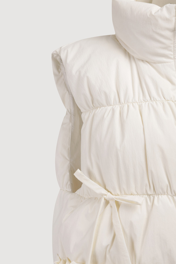 [Re-Order] 리본 다운 베스트 (다크 아이보리)는 겨울철 여성의 우아함과 따뜻함을 동시에 선사하는 다운 베스트입니다. 부드러운 촉감의 나일론과 스판덱스 혼방 소재, 그리고 샤이니 안감으로 고급스러운 착용감을 느낄 수 있습니다. 페미닌하고 캐주얼한 스타일을 연출하며, 리본 및 셔링 디테일로 포인트를 더했습니다. 투웨이 지퍼와 레귤러핏으로 편안한 착용감을 제공하며, 구스다운 충전재로 뛰어난 보온성을 자랑합니다. 데이트룩과 출근룩 등 다양한 TPO에 활용 가능하여, 캐주얼, 미니멀, 로맨틱 스타일을 즐기는 여성에게 추천합니다.
