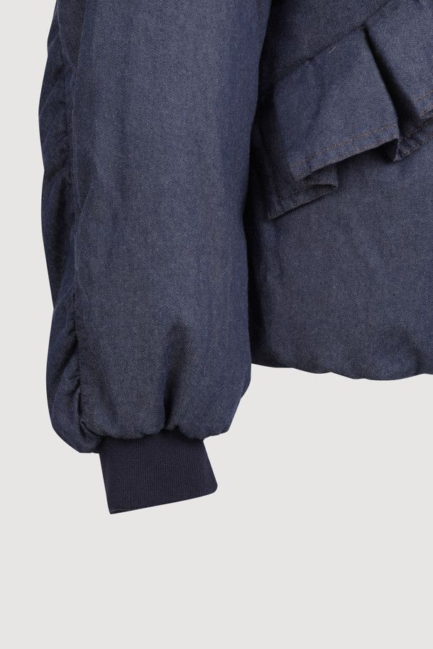 데님 구스다운 후디 점퍼 (블루)는 여성스러운 무드와 스포티한 스타일을 동시에 연출하는 아우터입니다. 두꺼운 데님 소재에 구스다운 충전재를 사용하여 보온성을 높였으며, 허리 아래 기장의 루즈핏으로 편안하게 착용할 수 있습니다. 소매는 니트 시보리로 마감하고 밑단에 밴딩을 더해 활동성을 더했습니다. 둥근 실루엣과 스트링 디테일이 돋보이는 겨울철 필수 아이템입니다. 스냅 여밈 방식으로 간편하게 착용 가능하며, 일상복으로 활용하기 좋습니다.
