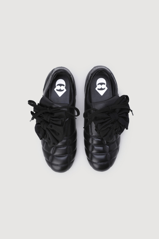 리본 장식이 돋보이는 블랙 컬러의 가죽 스니커즈입니다. 캐주얼하고 클래식한 스타일로, 일상 또는 가벼운 산책 시 편안하게 착용하기 좋습니다. 가볍고 부드러운 가죽 소재로 제작되었으며, 배색 컬러의 안창이 돋보입니다. 플랫 굽으로 편안한 착용감을 제공하며, 끈으로 묶어 발에 맞게 조절할 수 있습니다. 미니멀한 디자인에 사랑스러운 리본 디테일이 더해져 여성스러운 매력을 더합니다.
