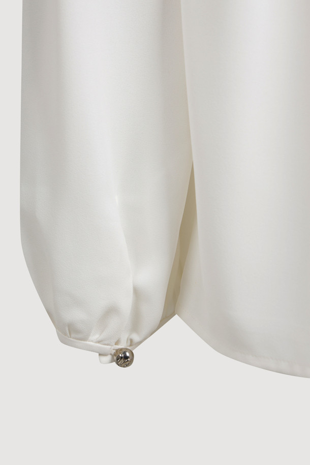 프릴 리본 넥 블라우스는 우아하고 페미닌한 무드를 연출하는 여성 블라우스입니다. 봄, 여름 시즌에 어울리는 얇고 부드러운 촉감의 화이트 컬러 블라우스로, 루즈핏 디자인에 긴 소매 기장으로 제작되었습니다. 리본 넥과 프릴 디테일이 여성스러운 포인트를 더하며, 가벼운 텍스처와 풍성한 실루엣이 특징입니다. 데이트룩, 카페룩, 모임룩 등 다양한 TPO에 클래식, 로맨틱, 미니멀 스타일로 연출하기 좋습니다. 실버 로고와 게더 주름 디테일이 고급스러움을 더합니다.
