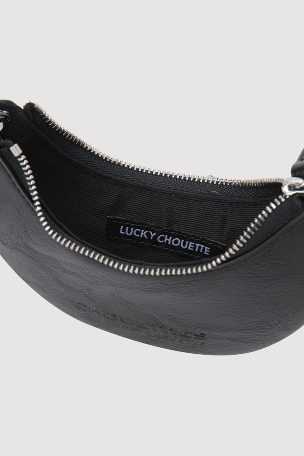 LUCKY CHOUETTE(럭키슈에뜨)의 Chouetties Moon Shape 미니 백 (블랙) 입니다. 달 모양 디자인과 은은한 광택감이 돋보이는 여성용 미니 백으로, 페미닌한 무드를 연출합니다. 인조가죽 소재로 제작되었으며, 금속 장식과 불박 레터링 디테일이 시크한 포인트를 더합니다. 내부에는 카드 수납이 가능한 실용적인 디자인이며, 크로스백 또는 투웨이 스타일로 연출할 수 있습니다. 데이트룩, 쇼핑룩, 모임룩 등 다양한 TPO에 활용하여 클래식, 미니멀, 시크한 스타일을 완성해보세요.
