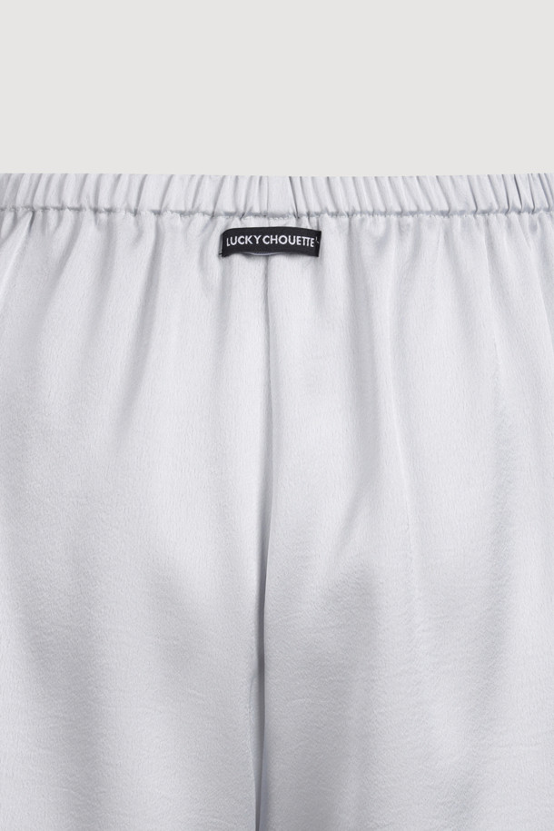 럭키슈에뜨의 Chouetties 프릴 숏팬츠 (실버)는 여성스러운 무드를 연출하는 숏 기장의 프릴 숏팬츠입니다. 은은한 광택감이 돋보이는 사틴 소재에 도트 무늬가 더해져 로맨틱하면서도 미니멀한 스타일을 완성합니다. 밑단 러플 디테일로 포인트를 더했으며, 루즈핏으로 편안한 착용감을 선사합니다. 데이트룩, 카페룩, 휴가룩 등 다양한 TPO에 활용 가능하며, 밴딩 처리로 활동성을 높였습니다. 뒷면에는 럭키슈에뜨 라벨 장식이 돋보입니다.
