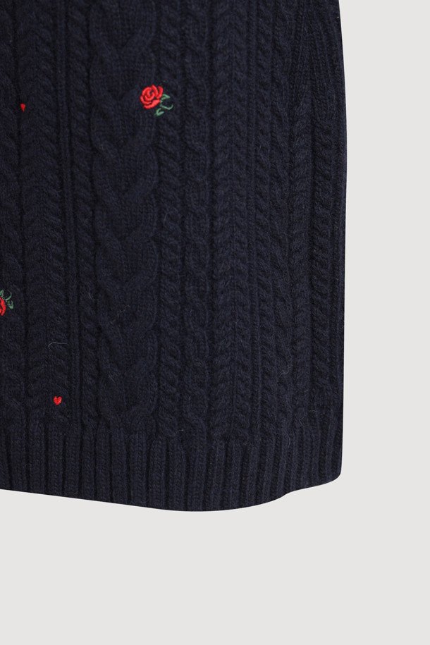 다크 네이비 컬러의 케이블 자수 니트 스커트입니다. 울, 캐시미어, 나일론 혼방 소재로 제작되어 부드러운 촉감과 두꺼운 두께감으로 따뜻하게 착용할 수 있습니다. H라인 미니스커트 디자인에 허리 밴딩, 자수 디테일, 니트 조직감이 더해져 미니멀하면서도 베이직한 스타일을 연출합니다. 가을, 겨울 시즌 데이트룩, 출근룩, 모임룩 등 다양한 TPO에 클래식, 미니멀, 시크한 무드로 활용하기 좋습니다. 레귤러핏으로 편안하게 착용 가능하며, 케이블 패턴과 플라워 자수 무늬가 특징입니다.
