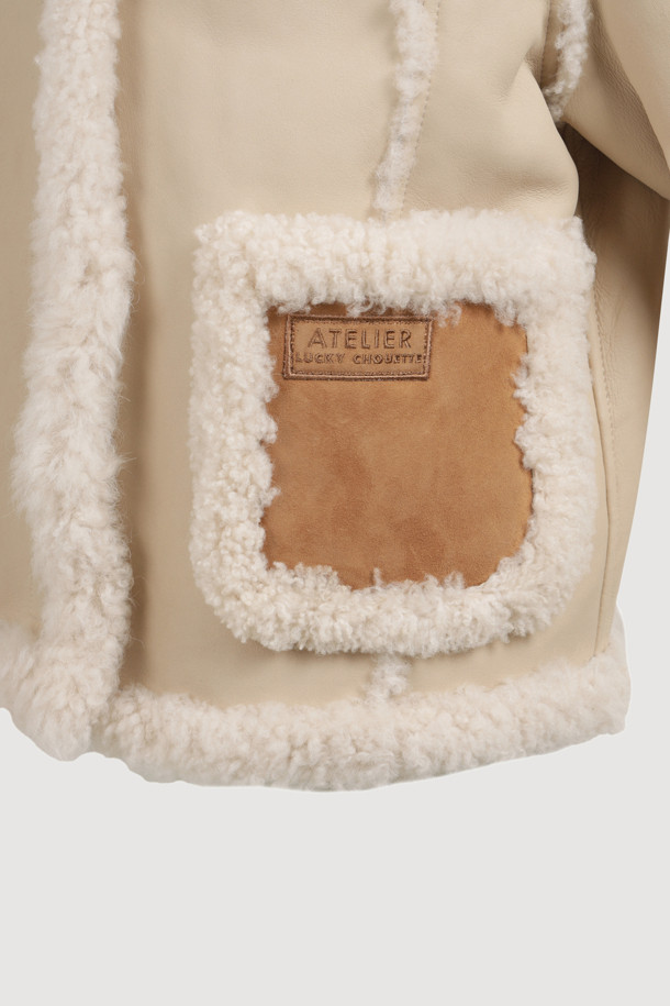 [Atelier] 램스킨 무스탕 재킷 (라이트 베이지)는 페미닌하고 고급스러운 무드를 연출하는 여성용 아우터입니다. 가을과 겨울, 데이트룩, 모임룩, 연말 모임룩에 적합하며, 클래식, 미니멀, 시크 스타일에 잘 어울립니다. 부드러운 램스킨과 스웨이드 소재를 사용하여 촉감이 뛰어나고, 루즈핏에 싱글 버튼 여밈 방식으로 편안하게 착용할 수 있습니다. 양쪽 배색 스웨이드 아웃포켓과 ATELIER 로고 장식, FUR 믹스로 디자인의 완성도를 높였습니다. 두꺼운 두께감으로 보온성을 더했으며, 긴 소매 기장과 레귤러 기장으로 어떤 스타일에도 잘 어울리는 활용도 높은 무스탕입니다.
