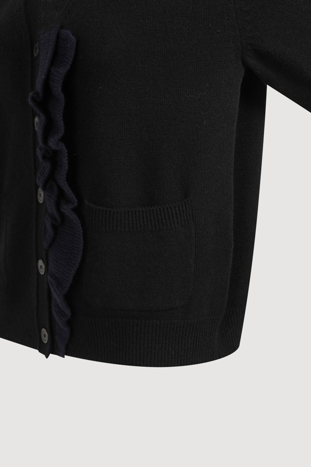 **프릴 브이넥 니트 가디건 (블랙)**

부드러운 촉감의 울, 캐시미어, 나일론 혼방 소재로 제작된 블랙 컬러의 여성용 가을/겨울 니트 가디건입니다. 브이넥 디자인에 앞단 배색 러플 디테일이 더해져 여성스러운 포인트를 더했으며, 넉넉한 루즈핏과 긴 소매 기장으로 편안한 착용감을 선사합니다. 버튼 여밈 방식으로 간편하게 착용할 수 있으며, 데이트룩, 모임룩, 출근룩 등 다양한 TPO에 활용 가능한 베이직 스타일의 아이템입니다. 클래식, 미니멀, 시크한 스타일을 연출하기 좋으며, 스커트와 세트로 착용하여 더욱 세련된 룩을 완성할 수 있습니다.
