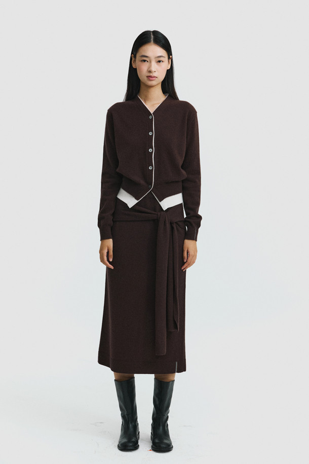 세련된 투톤 배색이 돋보이는 브라운 컬러의 여성 캐시미어 가디건입니다. 몽골산 캐시미어 100% 소재로 제작되어 부드러운 촉감과 뛰어난 보온성을 자랑합니다. V넥 라인과 밑단에 화이트 배색 포인트를 주어 클래식하면서도 세련된 무드를 연출합니다. 레귤러 핏에 얇은 두께감으로 간절기부터 겨울까지 다양하게 활용 가능하며, 버튼 여밈으로 간편하게 착용할 수 있습니다. 데이트룩, 출근룩, 모임룩 등 어떤 TPO에도 잘 어울리는 미니멀 스타일의 가디건입니다.
