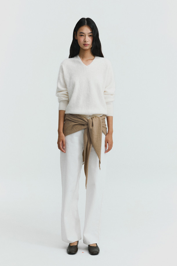 아이보리 컬러의 헤어리 캐시미어 스웨터입니다. 부드러운 촉감의 캐시미어 소재와 브러싱 처리, 기모감으로 포근하고 풍성한 텍스처를 선사합니다. 여유로운 핏과 브이넥 디자인으로 편안하면서도 세련된 스타일을 연출할 수 있습니다. 가을, 겨울 시즌에 어울리는 두꺼운 두께감과 긴 소매 기장으로 따뜻하게 착용 가능하며, 출근룩과 모임룩, 클래식, 미니멀 스타일 모두 소화 가능한 베이직 아이템입니다.
