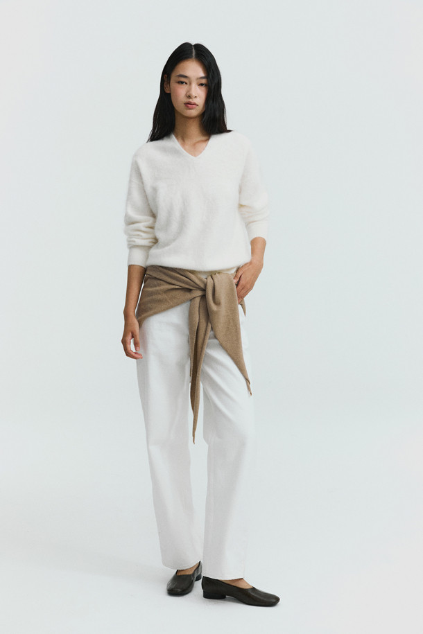 아이보리 컬러의 헤어리 캐시미어 스웨터입니다. 부드러운 촉감의 캐시미어 소재와 브러싱 처리, 기모감으로 포근하고 풍성한 텍스처를 선사합니다. 여유로운 핏과 브이넥 디자인으로 편안하면서도 세련된 스타일을 연출할 수 있습니다. 가을, 겨울 시즌에 어울리는 두꺼운 두께감과 긴 소매 기장으로 따뜻하게 착용 가능하며, 출근룩과 모임룩, 클래식, 미니멀 스타일 모두 소화 가능한 베이직 아이템입니다.
