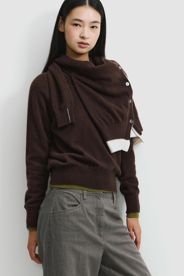 세련된 투톤 배색이 돋보이는 브라운 컬러의 여성 캐시미어 가디건입니다. 몽골산 캐시미어 100% 소재로 제작되어 부드러운 촉감과 뛰어난 보온성을 자랑합니다. V넥 라인과 밑단에 화이트 배색 포인트를 주어 클래식하면서도 세련된 무드를 연출합니다. 레귤러 핏에 얇은 두께감으로 간절기부터 겨울까지 다양하게 활용 가능하며, 버튼 여밈으로 간편하게 착용할 수 있습니다. 데이트룩, 출근룩, 모임룩 등 어떤 TPO에도 잘 어울리는 미니멀 스타일의 가디건입니다.
