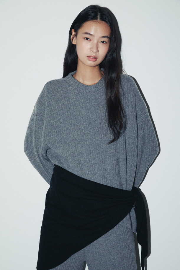 캐시미어와 양모 혼방으로 제작되어 부드러운 촉감을 자랑하는 그레이 컬러의 청키 스웨터입니다. 
라운드넥 디자인에 루즈핏으로 편안하게 착용 가능하며, 가을 겨울 시즌 데일리룩, 집콕룩, 카페룩 등 다양한 TPO에 활용하기 좋습니다. 
케이블 패턴과 와이드한 소매단, 둥근 밑단이 특징이며, 앞뒤 기장 차이로 포인트를 더했습니다. 
두꺼운 두께감으로 따뜻함을 유지하며, 베이직하면서도 캐주얼하고 클래식한 스타일을 연출합니다. 
긴 소매 기장으로 포근함을 더해 겨울철 필수 아이템으로 활용하기 좋습니다.