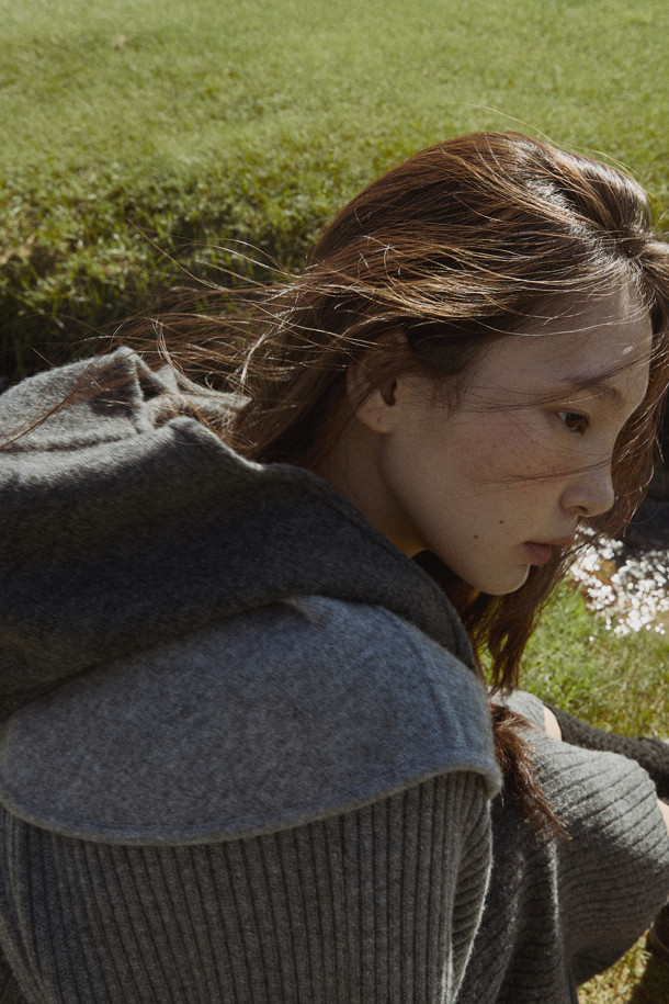 다크 그레이 후드 케이프는 여성스러운 매력을 더하는 아우터입니다. 양모와 캐시미어 혼방 소재로 제작되어 부드러운 촉감과 뛰어난 보온성을 자랑하며, 롱 기장에 루즈핏으로 편안하게 착용 가능합니다. 후드 디자인과 숄더 케이프 디테일이 돋보이며, 오픈 방식으로 간편하게 스타일링할 수 있습니다. 가을, 겨울철 출근룩 또는 모임룩에 클래식하면서도 모던한 스타일을 연출해보세요. 
