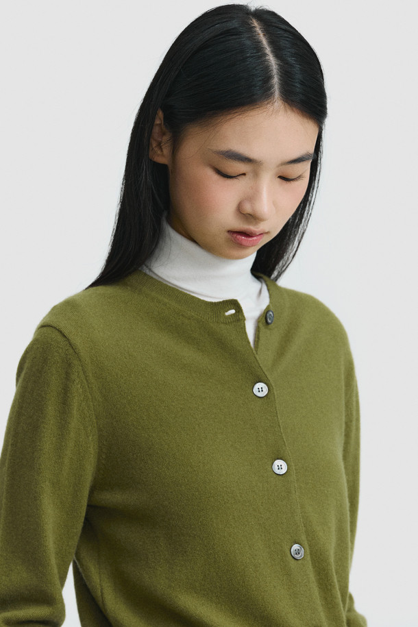 올리브 색상의 클래식 버튼 가디건입니다. 몽골산 캐시미어 100% 소재로 제작되어 부드러운 촉감을 선사하며, 가을과 겨울에 따뜻하게 착용할 수 있습니다. 레귤러 핏에 라운드넥 디자인으로, 일상, 출근룩, 오피스룩 등 다양한 TPO에 활용 가능합니다. 기본에 충실한 베이직하고 클래식한 스타일로, 라운드 스웨터와 셋업하여 연출할 수 있습니다. 얇은 두께로 휴대성이 높습니다.
