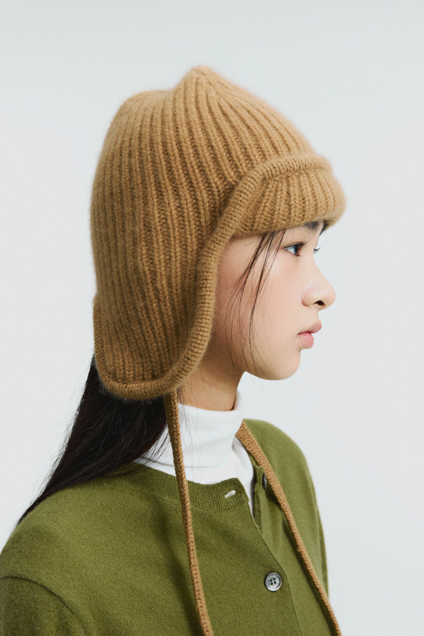 캐시미어 이어플랩 (카멜)은 부드러운 촉감의 몽골산 캐시미어 100%로 제작되어 뛰어난 보온성을 자랑하는 겨울철 필수 아이템입니다. 볼드한 골지 짜임과 턱선까지 내려오는 디자인으로 클래식, 미니멀, 캐주얼 등 다양한 스타일 연출에 용이합니다. 앞부분 접힘 디테일과 귀를 덮는 깊이로 디자인되어 따뜻함과 스타일을 동시에 잡았습니다. 차분하고 세련된 카멜 컬러는 어떤 룩에도 자연스럽게 어울립니다. 추운 겨울, 캐시미어 이어플랩 (카멜)으로 따뜻하고 멋스럽게 스타일을 완성하세요.
