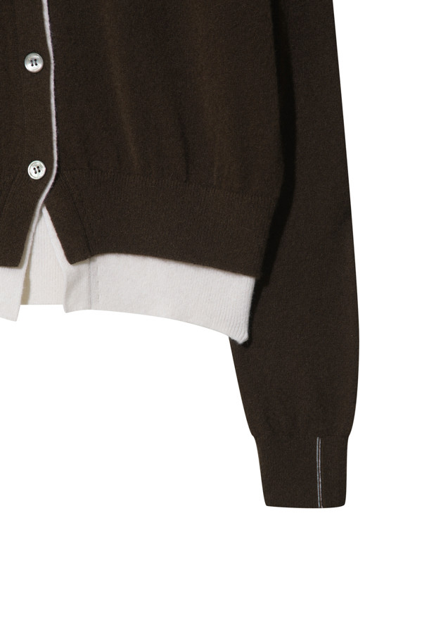 세련된 투톤 배색이 돋보이는 브라운 컬러의 여성 캐시미어 가디건입니다. 몽골산 캐시미어 100% 소재로 제작되어 부드러운 촉감과 뛰어난 보온성을 자랑합니다. V넥 라인과 밑단에 화이트 배색 포인트를 주어 클래식하면서도 세련된 무드를 연출합니다. 레귤러 핏에 얇은 두께감으로 간절기부터 겨울까지 다양하게 활용 가능하며, 버튼 여밈으로 간편하게 착용할 수 있습니다. 데이트룩, 출근룩, 모임룩 등 어떤 TPO에도 잘 어울리는 미니멀 스타일의 가디건입니다.
