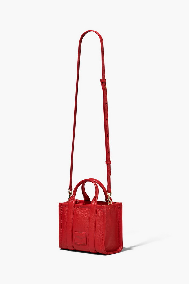 Leather Tote The Mini Tote_True Red (레더 토트 더 미니 토트_트루 레드)는 소가죽 소재의 미니 토트백입니다. 탈부착 및 길이 조절 가능한 스트랩과 상단 핸들을 갖춰 다양한 스타일 연출이 용이하며, 사각 쉐입과 로고 패턴으로 시크한 매력을 더합니다. 가방 내부에는 지퍼 포켓이 있어 소지품을 안전하게 보관할 수 있으며, 더스트백이 함께 제공됩니다. 데이트룩, 쇼핑룩, 모임룩 등 폭넓은 TPO에 클래식, 미니멀, 시크한 스타일을 완성할 수 있습니다. 
