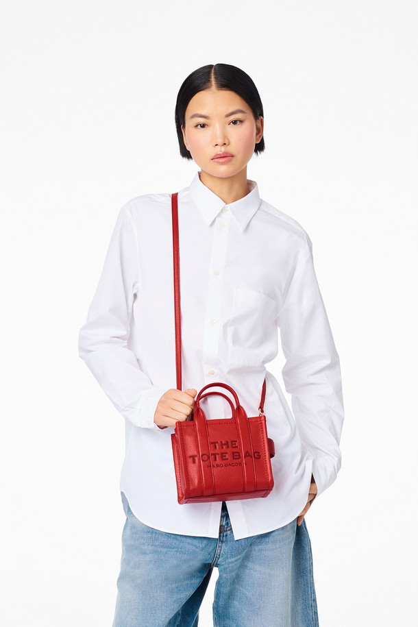 Leather Tote The Mini Tote_True Red (레더 토트 더 미니 토트_트루 레드)는 소가죽 소재의 미니 토트백입니다. 탈부착 및 길이 조절 가능한 스트랩과 상단 핸들을 갖춰 다양한 스타일 연출이 용이하며, 사각 쉐입과 로고 패턴으로 시크한 매력을 더합니다. 가방 내부에는 지퍼 포켓이 있어 소지품을 안전하게 보관할 수 있으며, 더스트백이 함께 제공됩니다. 데이트룩, 쇼핑룩, 모임룩 등 폭넓은 TPO에 클래식, 미니멀, 시크한 스타일을 완성할 수 있습니다. 
