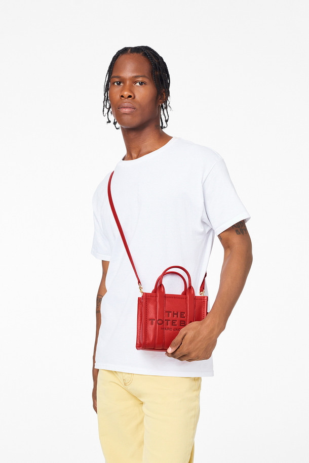 Leather Tote The Mini Tote_True Red (레더 토트 더 미니 토트_트루 레드)는 소가죽 소재의 미니 토트백입니다. 탈부착 및 길이 조절 가능한 스트랩과 상단 핸들을 갖춰 다양한 스타일 연출이 용이하며, 사각 쉐입과 로고 패턴으로 시크한 매력을 더합니다. 가방 내부에는 지퍼 포켓이 있어 소지품을 안전하게 보관할 수 있으며, 더스트백이 함께 제공됩니다. 데이트룩, 쇼핑룩, 모임룩 등 폭넓은 TPO에 클래식, 미니멀, 시크한 스타일을 완성할 수 있습니다. 
