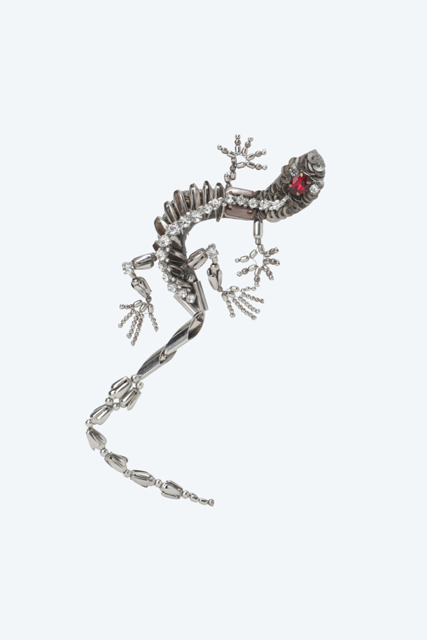 실버 컬러의 리자드 브로치입니다. 도마뱀 실루엣 디자인과 반짝이는 큐빅 디테일이 돋보이는 여성 액세서리입니다. 에폭시 소재로 제작되었으며, 14cm 크기로 제작되었습니다. 클래식, 로맨틱, 시크한 스타일 연출에 적합하며, 데이트룩, 모임룩, 파티룩 등 다양한 TPO에 활용할 수 있습니다.

