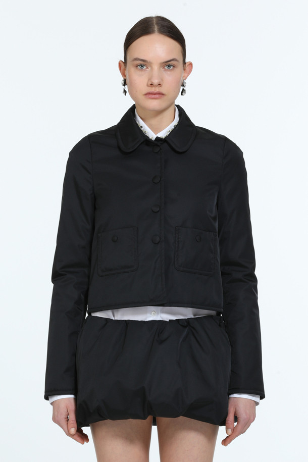 세련된 블랙 컬러의 패디드 쁘띠 재킷입니다. 봄, 가을 시즌에 어울리는 여성용 아우터로, 미니멀하고 클래식한 스타일을 연출합니다. 두꺼운 두께감과 광택감이 돋보이며, 크롭 기장과 버튼 여밈 방식으로 디자인되었습니다. 폴리아미드 소재로 제작되어 편안하면서도 시크한 분위기를 선사하며, 데이트룩, 모임룩 등 다양한 TPO에 활용 가능합니다. 겨울에는 패딩 안감으로 따뜻하게 착용할 수 있습니다.
