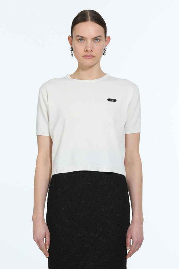 아이보리, 화이트 컬러의 "로고택" 하프슬리브 니트입니다. 부드러운 촉감의 버진울 100% 소재로 제작되어 봄, 여름 시즌에 착용하기 좋습니다. 레귤러핏 라운드넥 디자인에 가디건과 셋업 스타일링이 가능하며, 미니멀하고 베이직한 스타일을 연출합니다. 가슴 위 스몰 로고택 디테일이 특징이며, 일상, 카페룩, 데이트룩 등 다양한 TPO에 활용할 수 있습니다.
