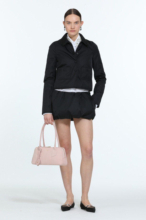 세련된 블랙 컬러의 패디드 쁘띠 재킷입니다. 봄, 가을 시즌에 어울리는 여성용 아우터로, 미니멀하고 클래식한 스타일을 연출합니다. 두꺼운 두께감과 광택감이 돋보이며, 크롭 기장과 버튼 여밈 방식으로 디자인되었습니다. 폴리아미드 소재로 제작되어 편안하면서도 시크한 분위기를 선사하며, 데이트룩, 모임룩 등 다양한 TPO에 활용 가능합니다. 겨울에는 패딩 안감으로 따뜻하게 착용할 수 있습니다.
