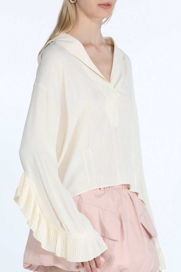 우아하고 페미닌한 무드의 아이보리 컬러 프릴 블라우스입니다. 실크 혼방 소재로 제작되어 부드러운 촉감을 선사하며, 브이넥 디자인과 크롭 기장으로 여성스러운 실루엣을 강조합니다. 긴 소매와 프릴 디테일이 특징이며, 데이트룩, 카페룩, 모임룩 등 다양한 TPO에 활용하기 좋습니다. 클래식, 미니멀, 로맨틱 스타일을 즐겨 입는 여성분들께 추천하는 제품입니다. 봄, 여름 시즌에 잘 어울리는 아이템입니다.
