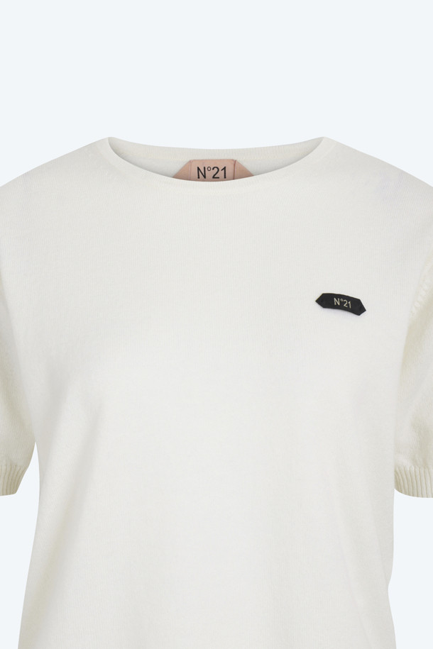 아이보리, 화이트 컬러의 "로고택" 하프슬리브 니트입니다. 부드러운 촉감의 버진울 100% 소재로 제작되어 봄, 여름 시즌에 착용하기 좋습니다. 레귤러핏 라운드넥 디자인에 가디건과 셋업 스타일링이 가능하며, 미니멀하고 베이직한 스타일을 연출합니다. 가슴 위 스몰 로고택 디테일이 특징이며, 일상, 카페룩, 데이트룩 등 다양한 TPO에 활용할 수 있습니다.
