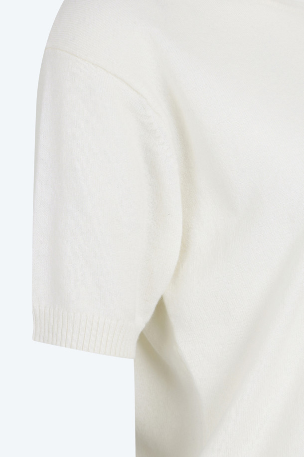 아이보리, 화이트 컬러의 "로고택" 하프슬리브 니트입니다. 부드러운 촉감의 버진울 100% 소재로 제작되어 봄, 여름 시즌에 착용하기 좋습니다. 레귤러핏 라운드넥 디자인에 가디건과 셋업 스타일링이 가능하며, 미니멀하고 베이직한 스타일을 연출합니다. 가슴 위 스몰 로고택 디테일이 특징이며, 일상, 카페룩, 데이트룩 등 다양한 TPO에 활용할 수 있습니다.
