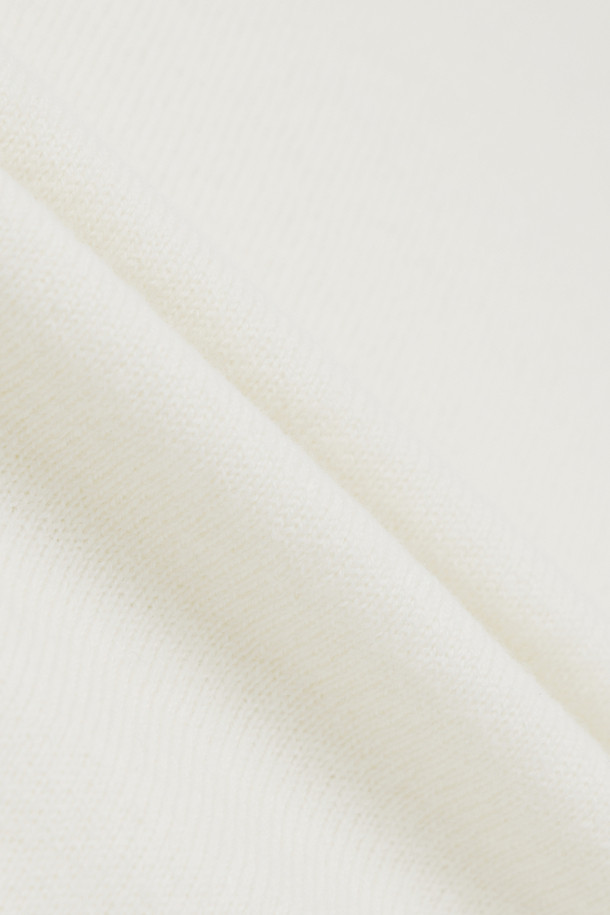 아이보리, 화이트 컬러의 "로고택" 하프슬리브 니트입니다. 부드러운 촉감의 버진울 100% 소재로 제작되어 봄, 여름 시즌에 착용하기 좋습니다. 레귤러핏 라운드넥 디자인에 가디건과 셋업 스타일링이 가능하며, 미니멀하고 베이직한 스타일을 연출합니다. 가슴 위 스몰 로고택 디테일이 특징이며, 일상, 카페룩, 데이트룩 등 다양한 TPO에 활용할 수 있습니다.
