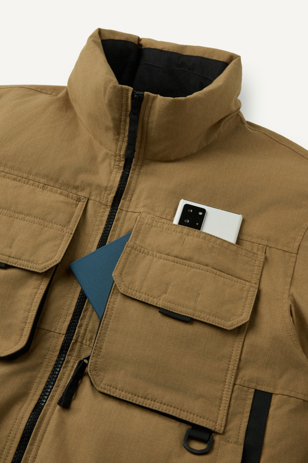 아라미드 쉴드 프리마로프트 워크 패딩 V2는 워크웨어와 일상, 스포티한 스타일을 아우르는 남녀 공용 겨울 아우터입니다. 베이지와 블랙 두 가지 색상으로 출시되었으며, 튼튼한 내구성과 보온성을 위해 아라미드, 코듀라, 프리마로프트 소재를 사용했습니다. 9개의 수납 포켓, D링 고리, 밑단 스트링 조절, 벨크로 시스템, 알루미늄 히팅 안감 등의 디테일이 돋보입니다. 발수 및 내열 기능으로 쾌적함을 더하며, 출근룩, 여행룩, 캠핑룩 등 다양한 TPO에 활용 가능합니다.
