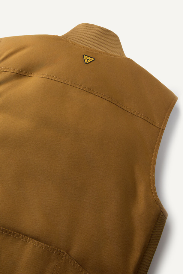 겨울철 일상과 아웃도어 활동에 적합한 헤비듀티 패딩 베스트입니다. 브라운 컬러의 무지 디자인으로, 유틸리티와 스포티한 스타일을 연출합니다. 겉감은 내구성이 뛰어난 코듀라와 나일론 소재를 사용하여 제작되었으며, 두꺼운 두께감으로 보온성을 높였습니다. 고기능성 패딩 충전재와 다수의 포켓, YKK 지퍼, 벨크로 포켓, 웨빙테이프 디테일 등 다양한 기능과 디자인 요소를 갖추었습니다. 내구성과 내마모성이 뛰어나며, 사이드 립 배색으로 포인트를 주어 세련된 겨울 데일리룩과 여행룩을 완성합니다.
