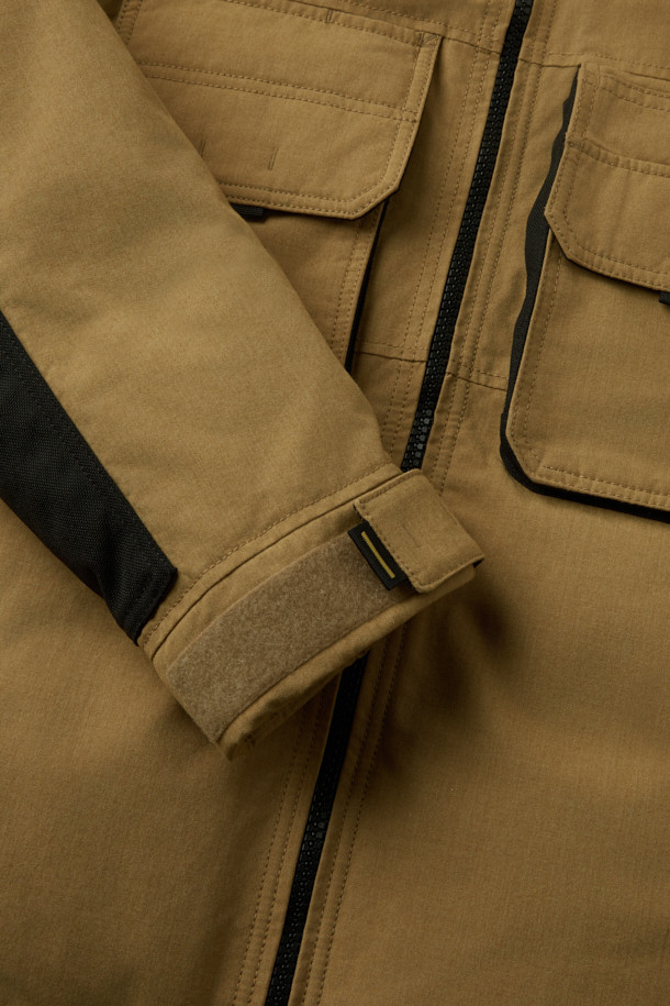 아라미드 쉴드 프리마로프트 워크 패딩 V2는 워크웨어와 일상, 스포티한 스타일을 아우르는 남녀 공용 겨울 아우터입니다. 베이지와 블랙 두 가지 색상으로 출시되었으며, 튼튼한 내구성과 보온성을 위해 아라미드, 코듀라, 프리마로프트 소재를 사용했습니다. 9개의 수납 포켓, D링 고리, 밑단 스트링 조절, 벨크로 시스템, 알루미늄 히팅 안감 등의 디테일이 돋보입니다. 발수 및 내열 기능으로 쾌적함을 더하며, 출근룩, 여행룩, 캠핑룩 등 다양한 TPO에 활용 가능합니다.
