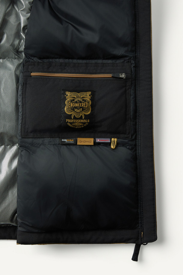 아라미드 쉴드 프리마로프트 워크 패딩 V2는 워크웨어와 일상, 스포티한 스타일을 아우르는 남녀 공용 겨울 아우터입니다. 베이지와 블랙 두 가지 색상으로 출시되었으며, 튼튼한 내구성과 보온성을 위해 아라미드, 코듀라, 프리마로프트 소재를 사용했습니다. 9개의 수납 포켓, D링 고리, 밑단 스트링 조절, 벨크로 시스템, 알루미늄 히팅 안감 등의 디테일이 돋보입니다. 발수 및 내열 기능으로 쾌적함을 더하며, 출근룩, 여행룩, 캠핑룩 등 다양한 TPO에 활용 가능합니다.
