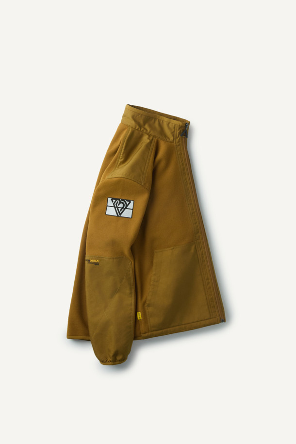 워크 시그니쳐 플리스 재킷 V3는 일상과 워크웨어 스타일을 아우르는 공용 플리스 재킷입니다. 부드러운 촉감의 허니콤 조직 본딩 플리스와 코듀라 500D 원단 덧댐으로 보온, 내구성, 방풍 기능을 갖춰 가을, 겨울철에 착용하기 좋습니다. 스탠다드핏에 지퍼와 스냅 여밈 방식을 적용했으며, 총 6개의 포켓과 겨드랑이 액션 분량, 목/소매 접밴드 처리로 활동성을 높였습니다. 브라운 컬러의 무지 디자인으로 캐주얼, 워크웨어, 스포티한 스타일을 연출할 수 있으며, 겨울 데일리룩, 산책룩, 캠핑룩에 적합합니다.
