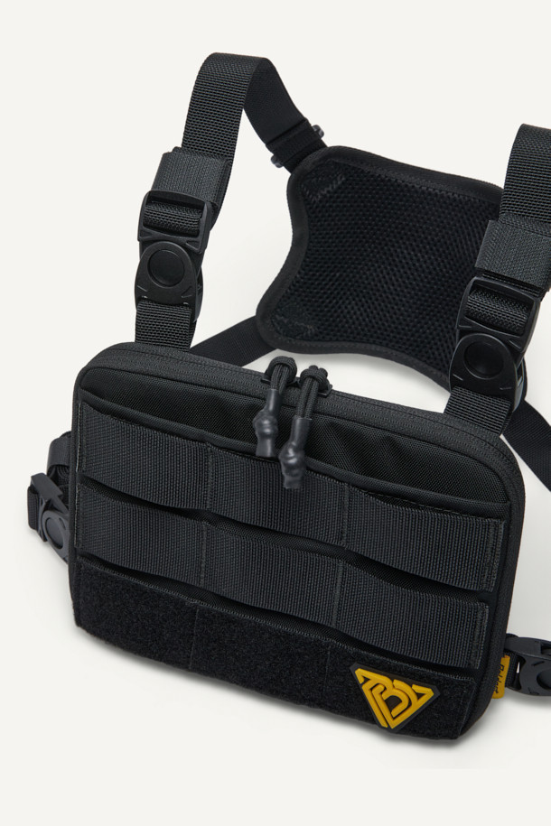 컴팩트 체스트 리그는 일상, 아웃도어, 워킹 활동에 적합한 가방입니다. 블랙 컬러의 나일론 소재로 제작되었으며, 컴팩트한 사이즈로 수납 기능을 제공합니다. 웨빙, 벨크로, 버클 등의 디자인 장식이 돋보이며, 몰리(MOLLE) 시스템, YKK 지퍼, 매쉬 그물망, 회전 버클, 고무 지퍼 손잡이, 스냅 단추 등 다양한 부자재를 사용하여 실용성을 높였습니다. 고프코어, 캐주얼, 스포티 스타일의 캠핑룩, 러닝룩에 매치하기 좋습니다.
