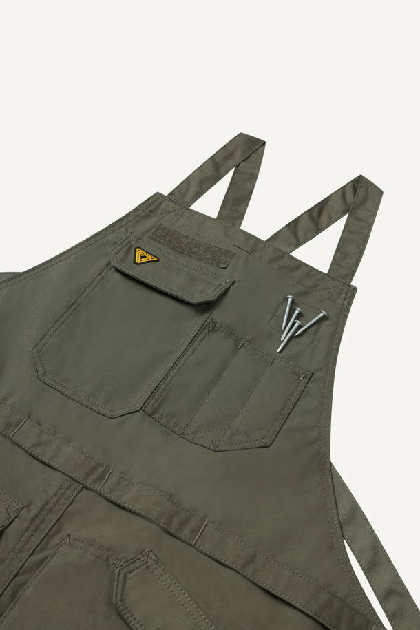 워크 툴 에이프런은 남녀 공용으로 제작되었으며, 카키와 올리브 두 가지 색상으로 만나볼 수 있습니다. 내구성이 뛰어나고 수납성이 뛰어난 워크웨어 에이프런으로, 나일론과 코듀라 소재를 사용하여 흡습, 속건, 내마모 기능까지 갖췄습니다. 가슴 포켓 4개, 하단 포켓 4개, 펜 포켓 등 넉넉한 수납공간을 제공하며, 벨크로, 몰리시스템, X자형 어깨끈으로 디자인에 포인트를 더했습니다.  길이 조절, 가랑이 트임, 패치 부착 가능 등 디테일한 기능성으로 워크샵룩, 캠핑룩, 가을 나들이룩, 워크웨어, 고프코어, 미니멀 스타일을 즐기는 분들께 적합합니다.
