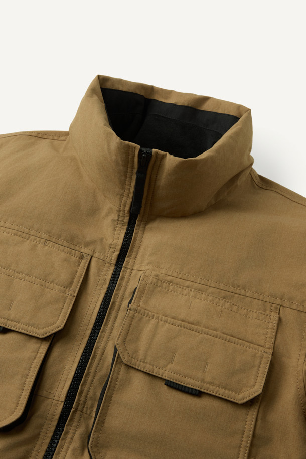 아라미드 쉴드 프리마로프트 워크 패딩 V2는 워크웨어와 일상, 스포티한 스타일을 아우르는 남녀 공용 겨울 아우터입니다. 베이지와 블랙 두 가지 색상으로 출시되었으며, 튼튼한 내구성과 보온성을 위해 아라미드, 코듀라, 프리마로프트 소재를 사용했습니다. 9개의 수납 포켓, D링 고리, 밑단 스트링 조절, 벨크로 시스템, 알루미늄 히팅 안감 등의 디테일이 돋보입니다. 발수 및 내열 기능으로 쾌적함을 더하며, 출근룩, 여행룩, 캠핑룩 등 다양한 TPO에 활용 가능합니다.
