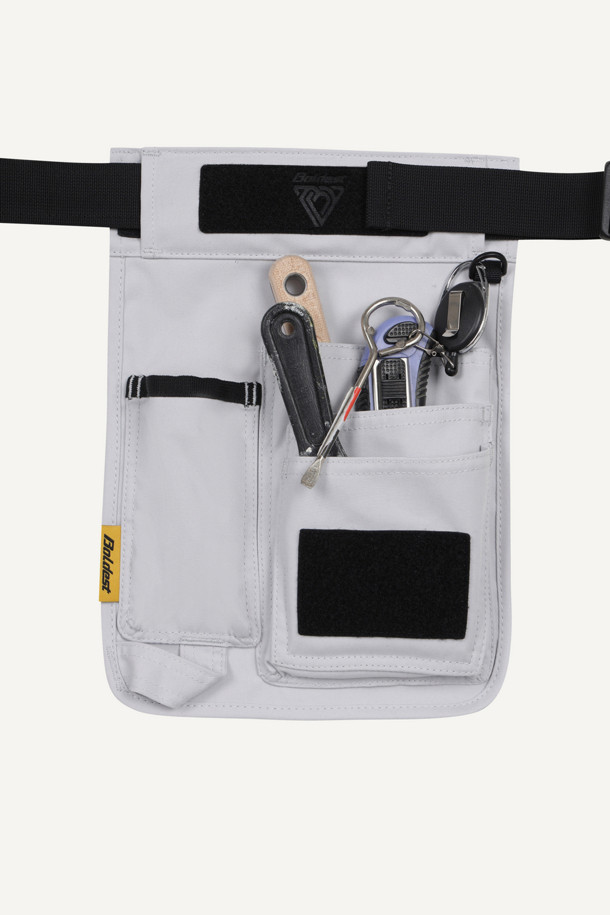 워크 페인터 벨트는 작업 시 편리함을 더하는 실용적인 아이템입니다. 튼튼한 나일론과 폴리에스테르 소재로 제작되어 내구성이 뛰어나며, 작업용, 페인팅, 미장 등 다양한 용도로 활용 가능합니다. 화이트와 블랙 두 가지 색상으로 출시되었으며, 수납, 탈부착, 커스터마이징 기능을 제공합니다. 대형 메인 파우치, 좌/우측 보조 파우치로 넉넉한 수납공간을 확보하고, D링, 벨크로, 와펜 디테일로 포인트를 더했습니다. 40mm 웨빙과 PU 코팅으로 고정력과 내구성을 강화하여 워크웨어, 고프코어, 캐주얼 스타일의 캠핑룩, 가을 나들이룩, 워크샵룩에 잘 어울립니다.
