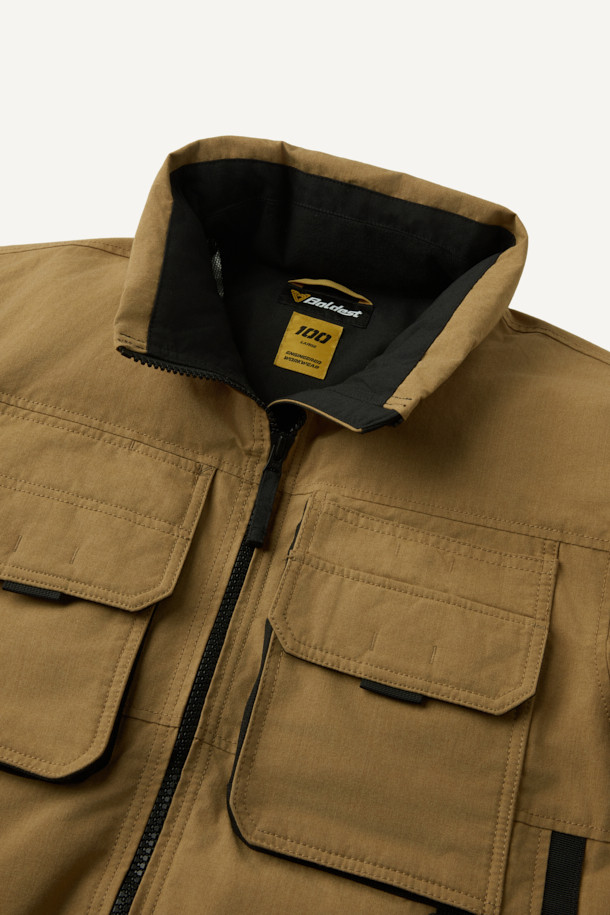 아라미드 쉴드 프리마로프트 워크 패딩 V2는 워크웨어와 일상, 스포티한 스타일을 아우르는 남녀 공용 겨울 아우터입니다. 베이지와 블랙 두 가지 색상으로 출시되었으며, 튼튼한 내구성과 보온성을 위해 아라미드, 코듀라, 프리마로프트 소재를 사용했습니다. 9개의 수납 포켓, D링 고리, 밑단 스트링 조절, 벨크로 시스템, 알루미늄 히팅 안감 등의 디테일이 돋보입니다. 발수 및 내열 기능으로 쾌적함을 더하며, 출근룩, 여행룩, 캠핑룩 등 다양한 TPO에 활용 가능합니다.
