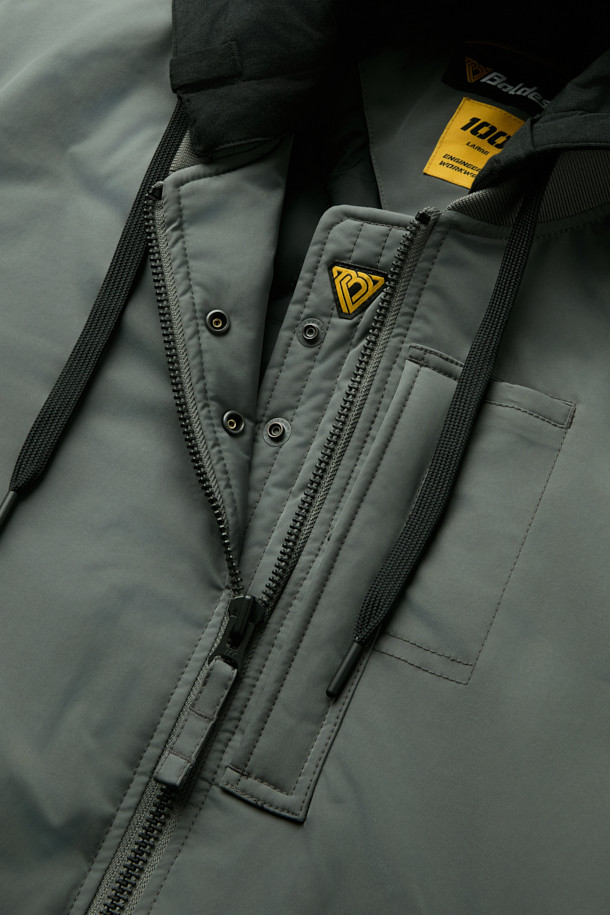 워크 MA-1 패딩 파카 V4는 일상과 워크웨어 스타일을 아우르는 남녀 공용 아우터입니다. 두꺼운 두께감의 폴리에스테르 소재에 안감은 패딩 처리하여 가을, 겨울철 뛰어난 보온성을 제공하며 일상적인 활동은 물론 출근룩으로도 활용 가능합니다. 밀리터리, 스포티 무드를 동시에 느낄 수 있으며, 무지 디자인에 후드 탈부착, YKK 2WAY 지퍼, 13개 포켓 시스템, 벨크로, 시보리, 아일렛 등 다양한 디테일이 돋보입니다. 생활 방수, 방풍 기능으로 외부 환경으로부터 보호하며, 컴포트핏 레귤러 기장으로 편안한 착용감을 선사합니다.
