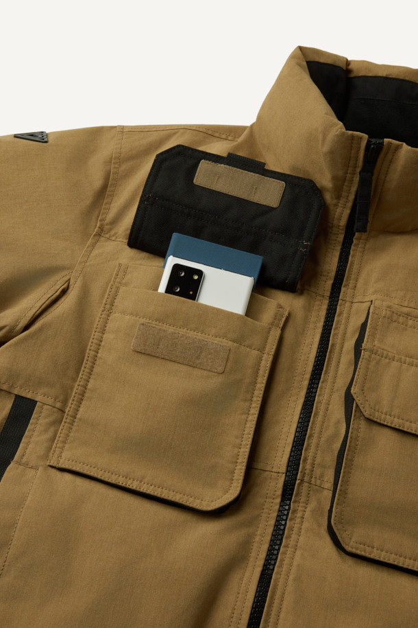 아라미드 쉴드 프리마로프트 워크 패딩 V2는 워크웨어와 일상, 스포티한 스타일을 아우르는 남녀 공용 겨울 아우터입니다. 베이지와 블랙 두 가지 색상으로 출시되었으며, 튼튼한 내구성과 보온성을 위해 아라미드, 코듀라, 프리마로프트 소재를 사용했습니다. 9개의 수납 포켓, D링 고리, 밑단 스트링 조절, 벨크로 시스템, 알루미늄 히팅 안감 등의 디테일이 돋보입니다. 발수 및 내열 기능으로 쾌적함을 더하며, 출근룩, 여행룩, 캠핑룩 등 다양한 TPO에 활용 가능합니다.
