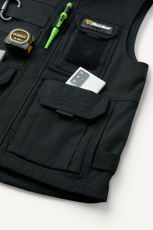 헤비듀티 베스트 V2는 작업용 또는 일상에서 밀리터리, 워크웨어 스타일을 연출하기 좋은 남녀 공용 베스트입니다. 블랙 색상의 무지 디자인으로, 사계절 착용 가능하며 레귤러핏과 레귤러 기장으로 편안함을 제공합니다. 튼튼한 코듀라와 나일론 소재를 사용하여 두꺼운 두께감과 뻣뻣한 촉감을 선사하며, 방수, 내구성, 수납 기능을 갖췄습니다. 총 15개의 다수 포켓, 몰리 시스템, 벨크로 패치 부착 가능, YKK 지퍼, 제전성 안감 등의 특징을 더해 기능성을 높였습니다. 캠핑룩, 출근룩, 워크웨어, 미니멀, 캐주얼 스타일 모두 소화 가능한 활용도 높은 아이템입니다.
