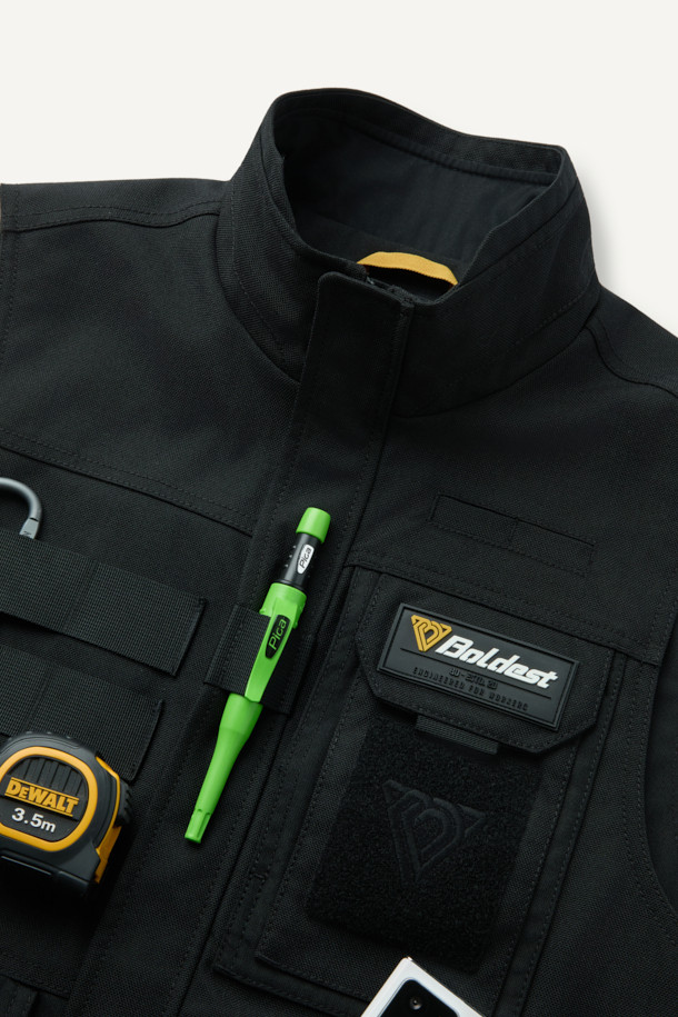 헤비듀티 베스트 V2는 작업용 또는 일상에서 밀리터리, 워크웨어 스타일을 연출하기 좋은 남녀 공용 베스트입니다. 블랙 색상의 무지 디자인으로, 사계절 착용 가능하며 레귤러핏과 레귤러 기장으로 편안함을 제공합니다. 튼튼한 코듀라와 나일론 소재를 사용하여 두꺼운 두께감과 뻣뻣한 촉감을 선사하며, 방수, 내구성, 수납 기능을 갖췄습니다. 총 15개의 다수 포켓, 몰리 시스템, 벨크로 패치 부착 가능, YKK 지퍼, 제전성 안감 등의 특징을 더해 기능성을 높였습니다. 캠핑룩, 출근룩, 워크웨어, 미니멀, 캐주얼 스타일 모두 소화 가능한 활용도 높은 아이템입니다.
