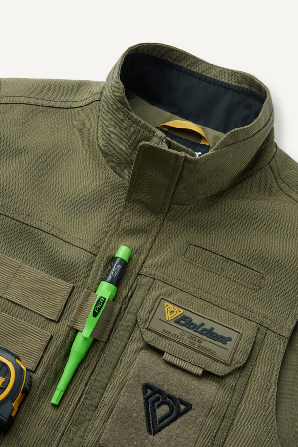 헤비듀티 베스트 V2는 작업용 또는 일상복으로 활용 가능한 남녀 공용 베스트입니다. 카키와 올리브 두 가지 색상으로 출시되었으며, 사계절 착용 가능한 두꺼운 두께감의 코듀라, 나일론 혼방 소재로 제작되었습니다. 밀리터리, 워크웨어 스타일을 기반으로 무지 패턴과 레귤러핏 디자인을 적용했으며, 총 15개의 포켓, 몰리 시스템, 벨크로 패치 부착 가능, YKK 지퍼, 제전성 안감 등 뛰어난 기능성을 자랑합니다. 캠핑룩, 출근룩, 워크웨어, 캐주얼, 고프코어 스타일 연출에 적합합니다.
