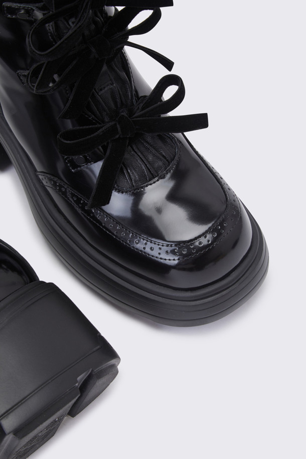 **두기 레이스업 부츠(블랙)**는 여성스러운 매력을 강조하는 부츠입니다. 복스가죽과 양가죽 소재로 제작되어 고급스러운 분위기를 자아내며, 7cm 청키힐이 안정적인 착화감을 제공합니다. 라운드 앞코와 블랙 컬러, 무지 디자인으로 어떤 스타일에도 쉽게 매치할 수 있으며, 발목 주름 디테일과 벨벳 리본끈, 내측 지퍼가 특징입니다. 특히, 앵클 탑라인과 IP소재 몰드가 편안한 착용감을 선사하여 데이트룩, 겨울 데일리룩, 모임룩 등 다양한 TPO에 활용 가능합니다. 클래식, 미니멀, 시크 스타일을 즐기는 여성에게 추천합니다.
