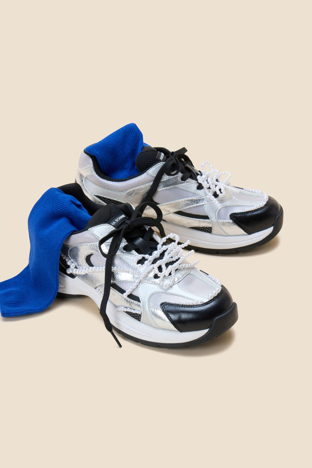 딜라이트 스니커즈(실버)는 여성스러운 무드를 연출하는 캐주얼 운동화입니다. 은은하게 빛나는 유광 소재와 라운드 앞코 디자인으로 편안하면서도 세련된 스타일을 완성합니다. 일상, 캐주얼 룩에 매치하기 좋으며, 봄, 여름, 가을 계절에 활용할 수 있습니다. 끈으로 조절하는 로우탑 디자인에 비즈 장식과 진주 오너먼트가 포인트로 더해져 스포티하면서도 페미닌한 매력을 줍니다. 동네 마실룩이나 산책룩에 가볍게 착용하여 스타일리시함을 더해보세요.
