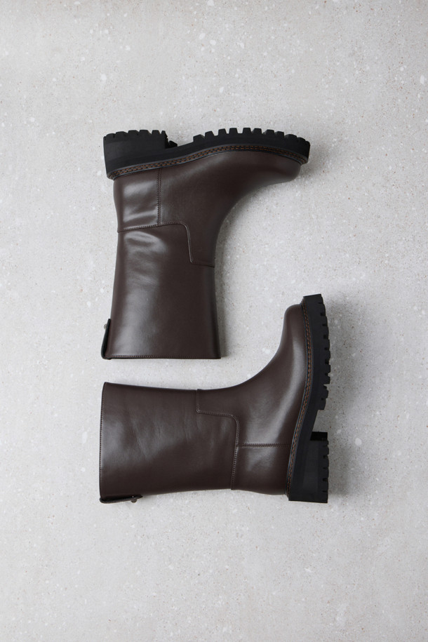 Fev_Young muze 부츠(브라운)는 여성들을 위한 미들 기장의 부츠입니다. 라운드 앞코와 통굽 디자인, 그리고 무지 패턴으로 미니멀하고 클래식한 분위기를 연출합니다. 합성가죽 소재에 볼드한 아웃솔과 러기드 아웃솔 디자인, FEV 심볼 적용으로 포인트를 더했습니다. 출근룩과 모임룩 모두에 어울리며, 가을과 겨울 시즌에 따뜻하고 스타일리시하게 착용할 수 있습니다. 
